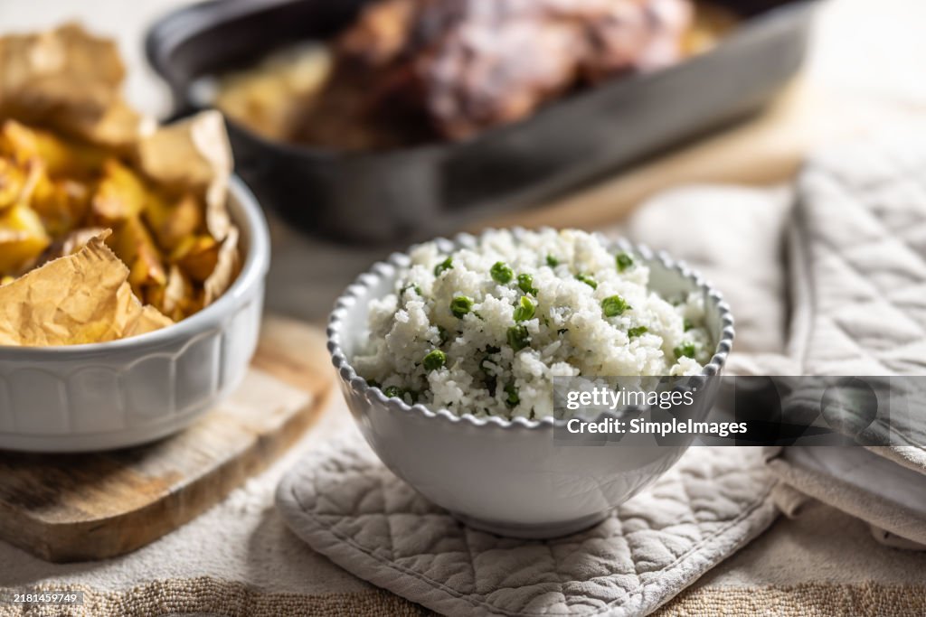 Jasmine rice with green peas garnished with parsley in a white bowl as a side dish to the main meal