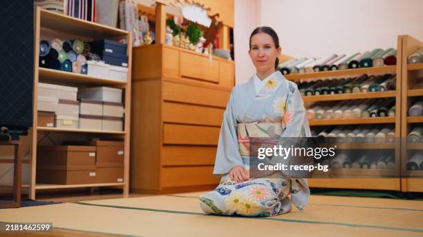 portrait of female tourist experiencing and learning wearing japanese traditional clothing kimono - sitting on ground stock pictures, royalty-free photos & images