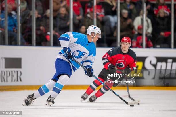 il giocatore dribbla abilmente il disco, eludendo i difensori con movimenti rapidi e passaggi precisi. - difensore hockey su ghiaccio foto e immagini stock