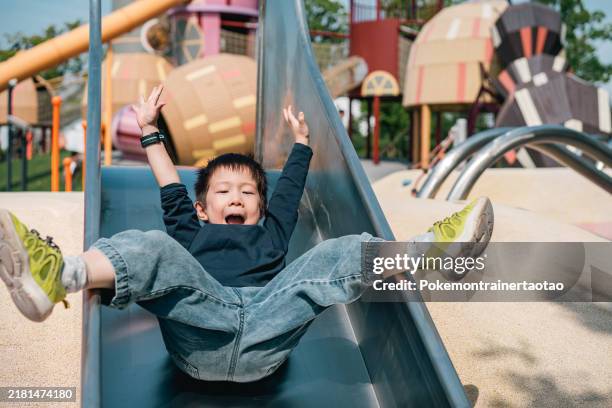 glücklicher junge spielt folie - rutsche stock-fotos und bilder