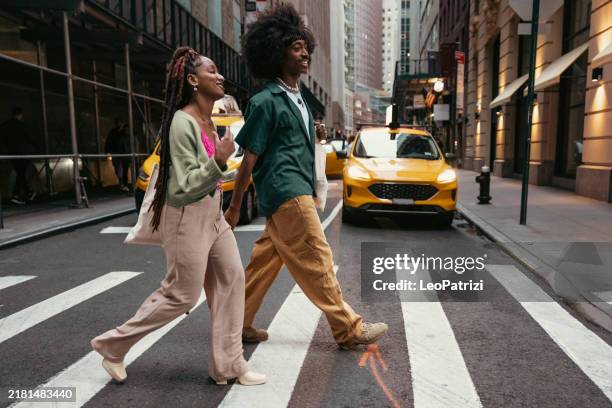 two friends in new york city - couple crossing street stock pictures, royalty-free photos & images
