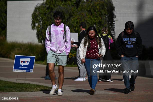 Grand Valley State University walk past a vote sign on the campus of Grand Valley State University on October 16, 2024 in Allendale, Michigan. As the...