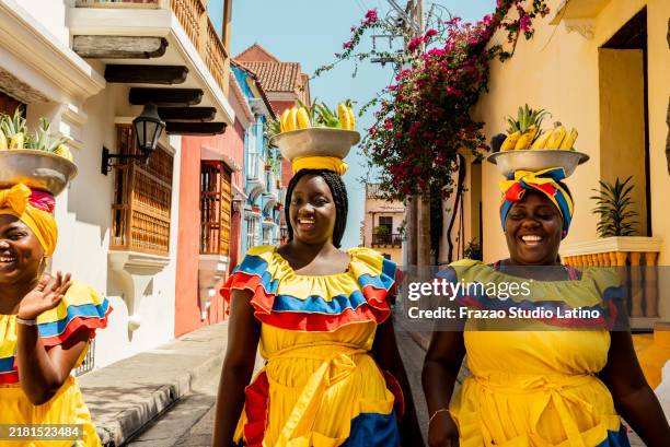 palenqueras walking on the street in cartagena, colombia - colombia stockfoto's en -beelden