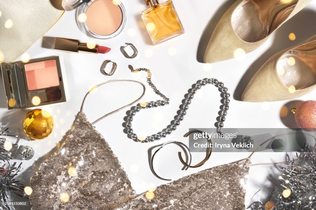 Holiday's Christmas and New Year Fashion Dress Collection with Trendy Clothes and Accessories, Jewelry, Make-up Cosmetic Products for women in Gold, Beige and Pink colours and Christmas Decorations, Christmas Lights.