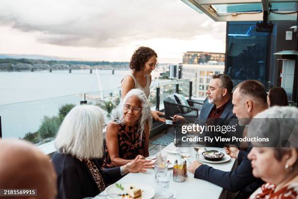 man paying for dinner with friends - balcony restaurant stock pictures, royalty-free photos & images