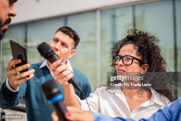 periodistas entrevistando a un hombre al aire libre - periodista fotografías e imágenes de stock