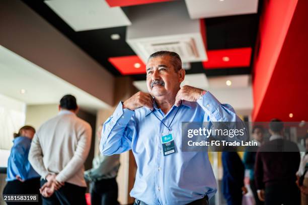 hombre de negocios mayor que camina durante el seminario de negocios - tarjeta de nombre fotografías e imágenes de stock