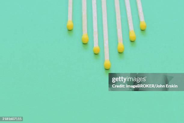yellow tip wooden matches arranged in shape of pyramid on green background - john peaks stock pictures, royalty-free photos & images