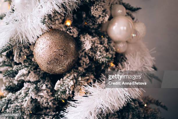 christmas snowy tree with white and silver balls and festive decorations with glitter on black background with defocused lights. concept of celebrating christmas and new year. - ramo albero natale bianco foto e immagini stock