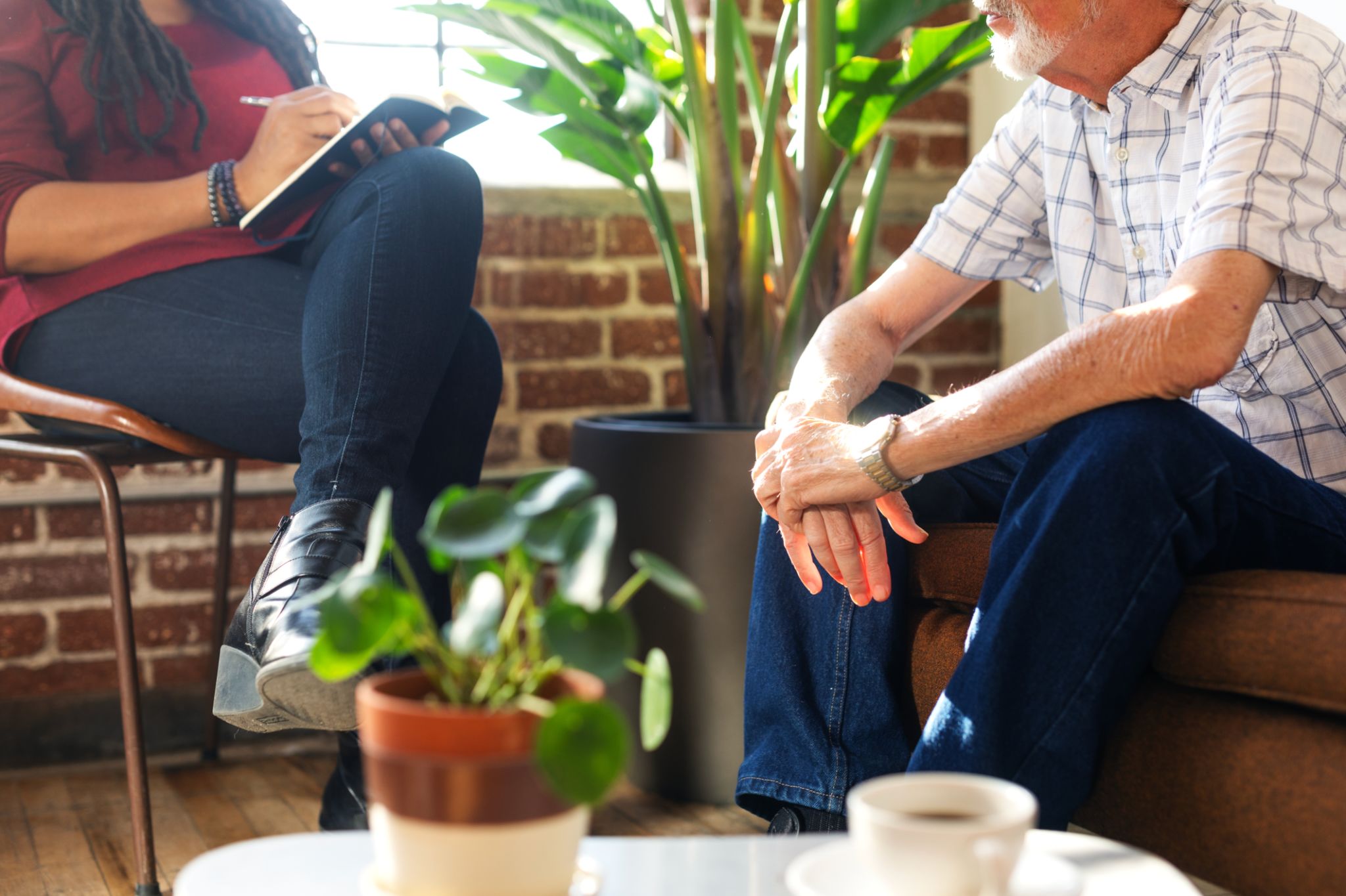 Therapy meeting with two people, one taking notes, the other listening. Therapy meeting with two people, one taking notes, the other listening.