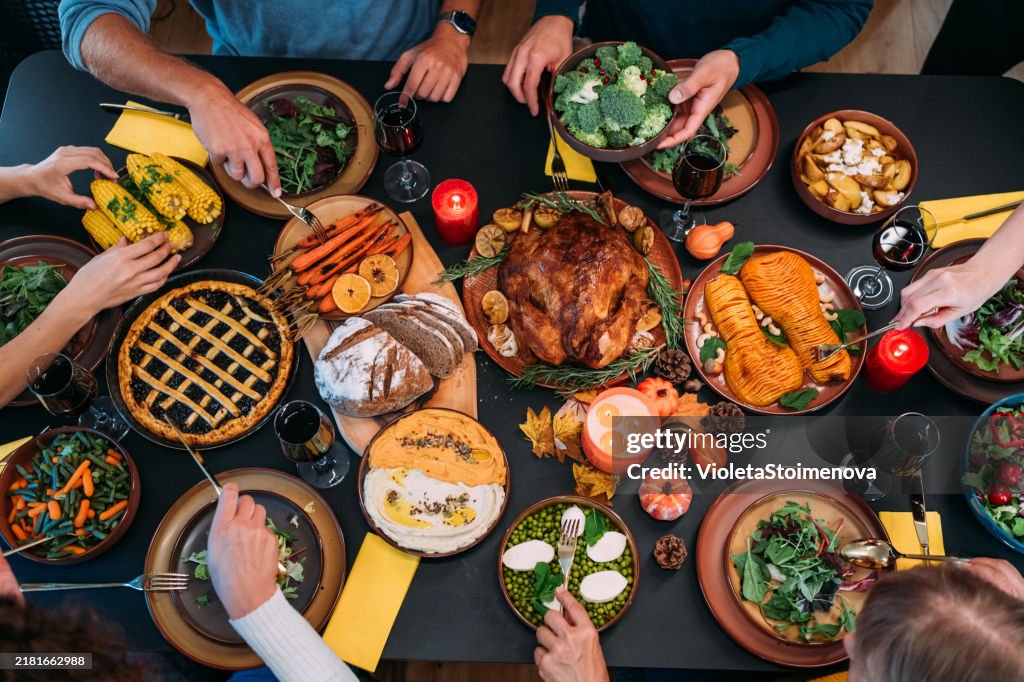 Happy family celebrating Thanksgiving at dining table.