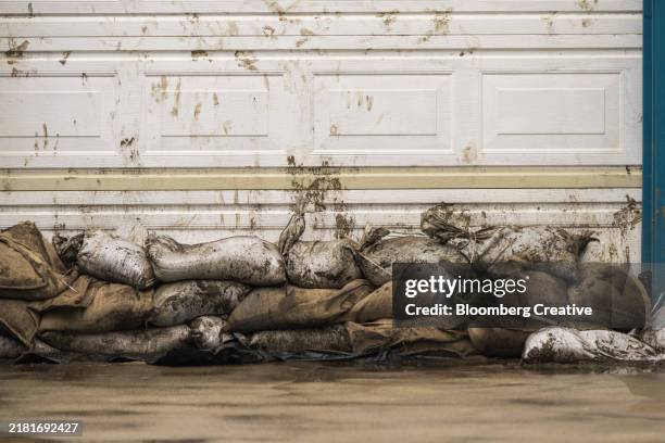 sandbags stacked in front of a garage door - sandbag stock pictures, royalty-free photos & images