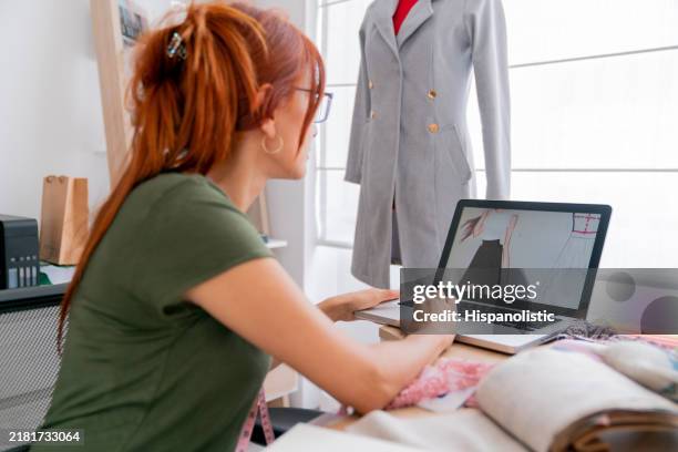 fashion designer using her laptop while working at her atelier - celebrity stylist stock pictures, royalty-free photos & images