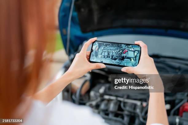 woman having problems with her car and taking a picture of the engine - photographing stock pictures, royalty-free photos & images