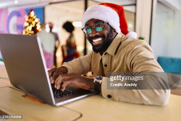 smiling man sending emails from the office - christmas zoom stock pictures, royalty-free photos & images
