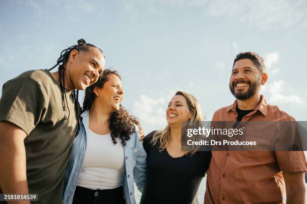 amigos abrazando sonriendo - ocio fotografías e imágenes de stock