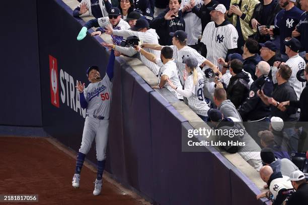 Mookie Betts of the Los Angeles Dodgers catches a fly ball in foul territory despite fan interference during the first inning of Game Four of the...