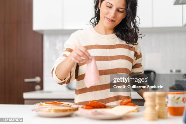woman grabbing ham slices for the sandwich in the kitchen - making a sandwich stock pictures, royalty-free photos & images