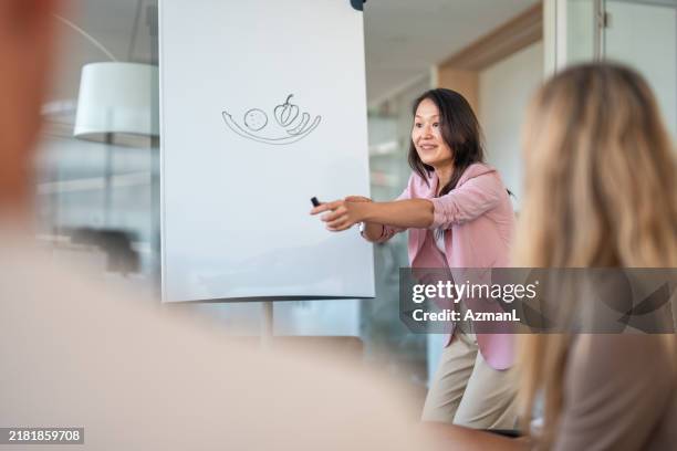 asian businesswoman leading team building activity - office games stock pictures, royalty-free photos & images
