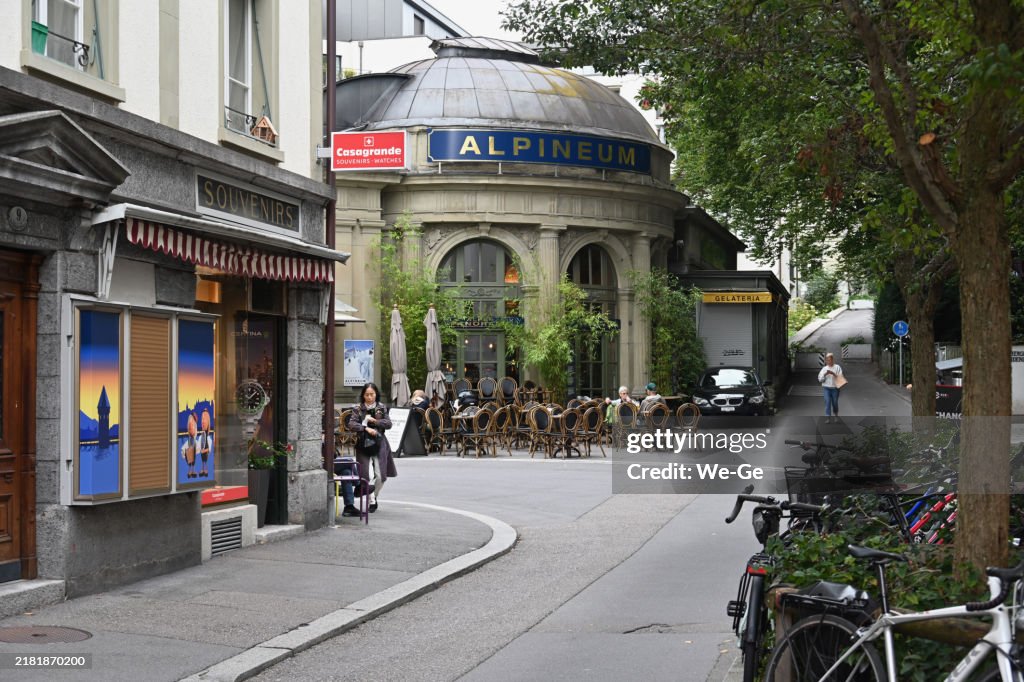 Tourists and locals sit in the street café in front of the Alpineum, a museum and Alpine diorama in Lucerne on Lion Square (Löwenplatz).