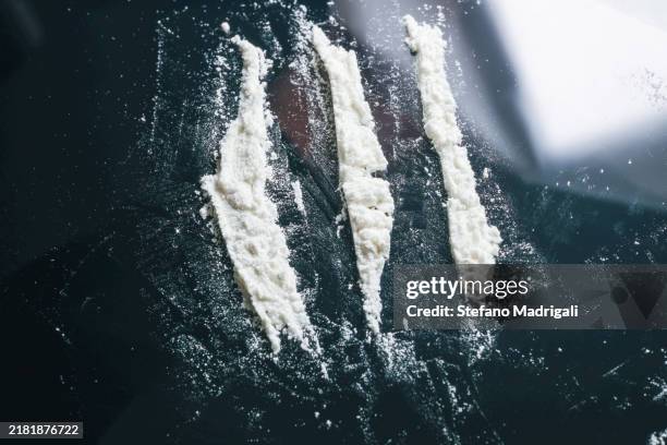 white powder on dark reflective surface - cocaine-ivory stock pictures, royalty-free photos & images