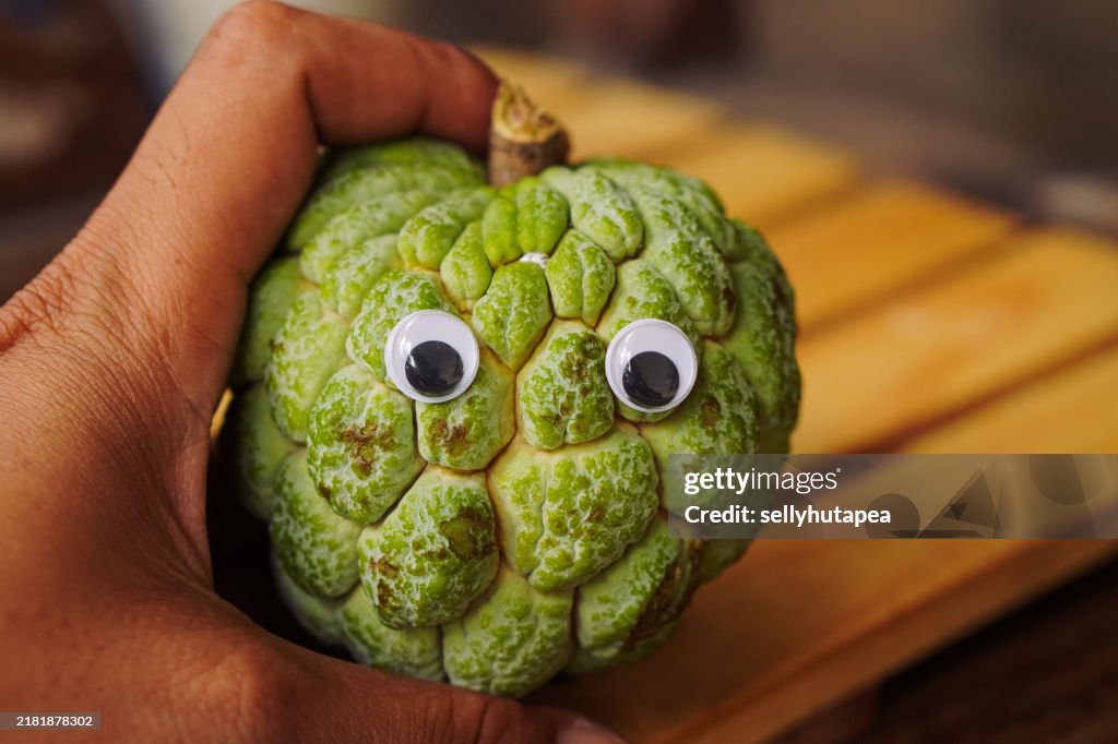 Sugar Apple with emoji on wood table