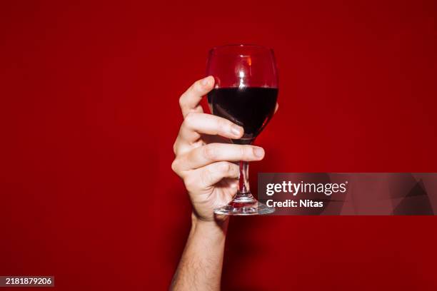 hand holding red wine - bordeauxrood stockfoto's en -beelden
