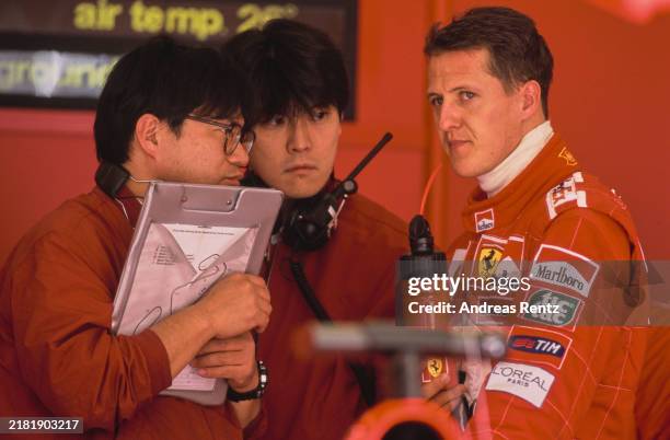 Michael Schumacher from Germany, driver of the Scuderia Ferrari Marlboro Ferrari F1-2001 Ferrari V10 in conversation with two Bridgestone tyre...