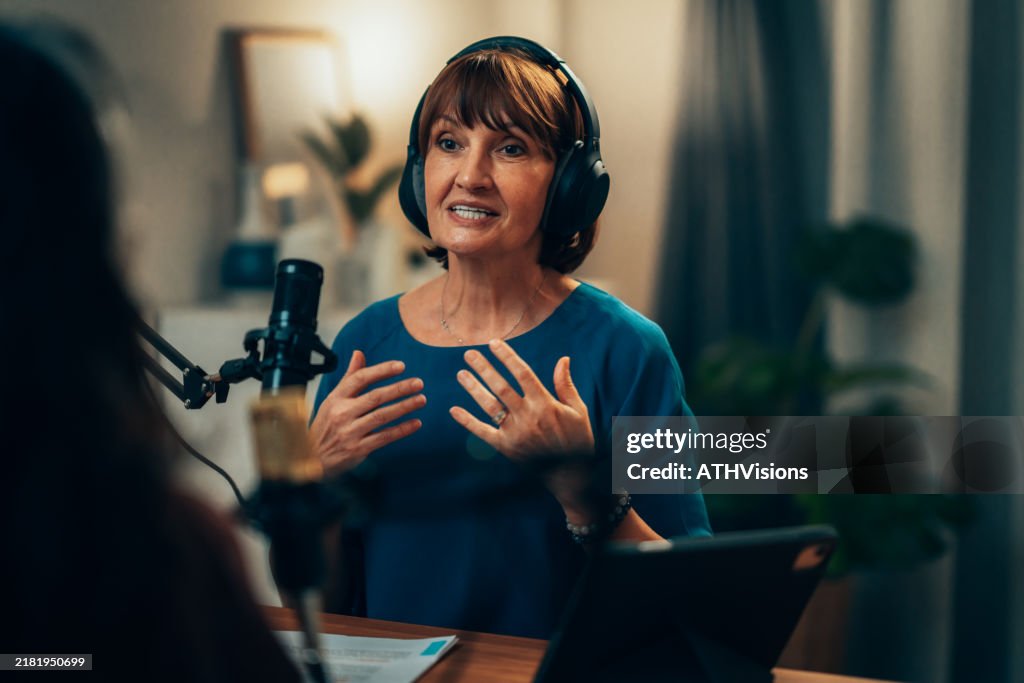 Mature Woman Hosting Podcast with Professional Microphone and Headphones