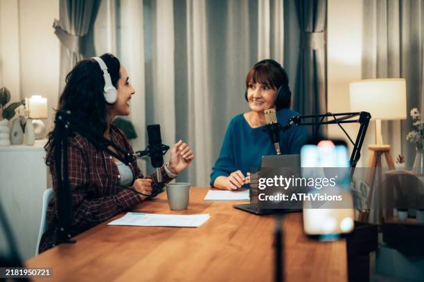female podcasters in studio: senior host and young guest enjoying podcast dialogu - locutor-de-rádio imagens e fotografias de stock