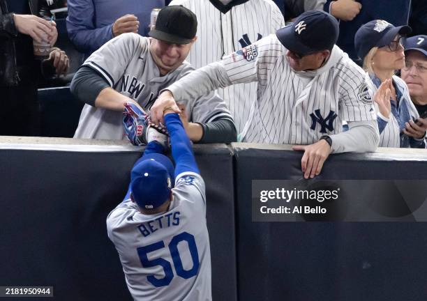 Fans Austin Capobianco and John Peter interfere with Mookie Betts of the Los Angeles Dodgers as he attempts to catch a fly ball in foul territory...