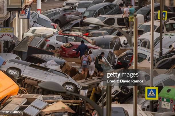 Cars are piled in the street with other debris after flash floods hit the region on October 30, 2024 in the Sedaví area of Valencia, Spain. Spanish...