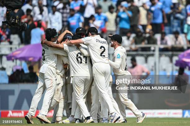 New Zealand's players celebrate after winning the third and final Test cricket match between India and New Zealand at the Wankhede Stadium in Mumbai...