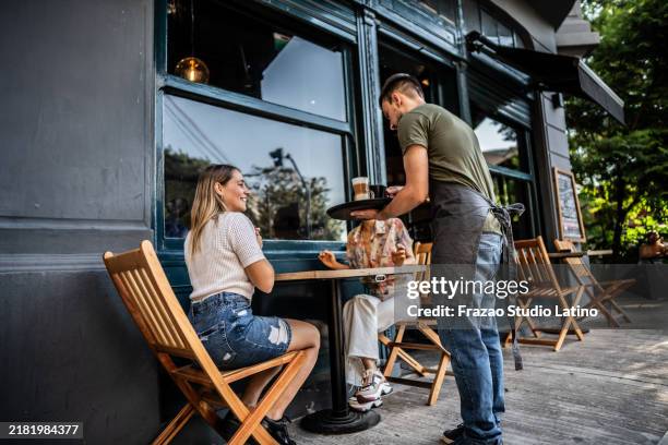 camarero sirviendo a los clientes en una cafetería - terraza de cafetería fotografías e imágenes de stock