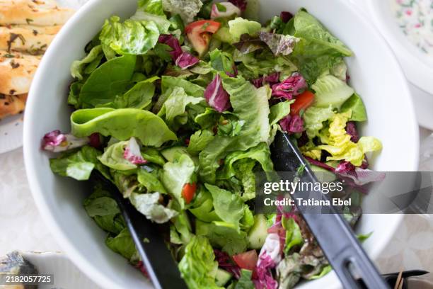 a bowl of green salad on the table - ensalada verde fotografías e imágenes de stock