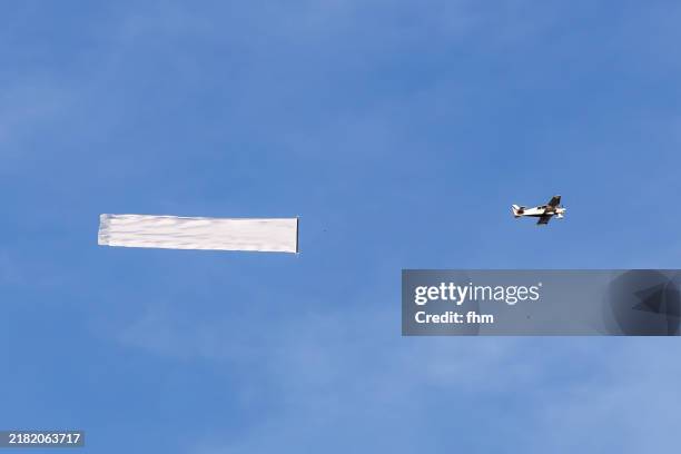 airplane with advertising banner in the sky - plane with banner stock pictures, royalty-free photos & images