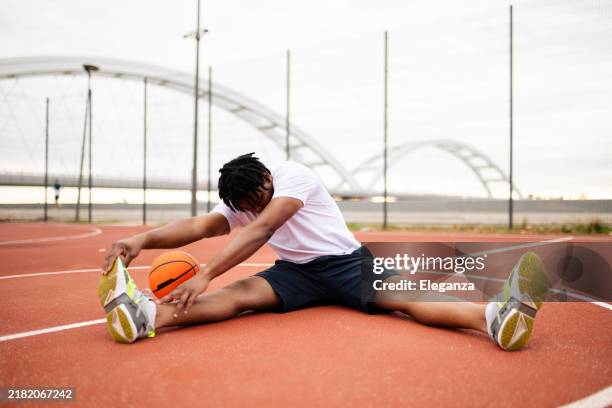 joven jugador de baloncesto africano confundido practicando al aire libre. ajuste afro hombre en movimiento y movimiento. estilo de vida atlético y deportivo - ejercicio de entrenamiento deportivo fotografías e imágenes de stock