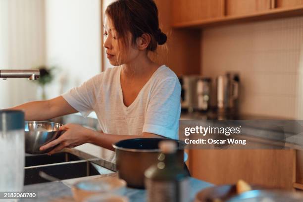 asian woman cooking in domestic kitchen - housewife stock pictures, royalty-free photos & images