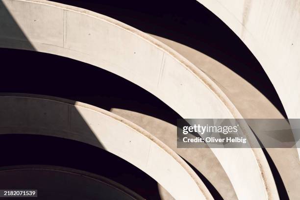 curved geometry and light play in a parking structure - architecture stock pictures, royalty-free photos & images