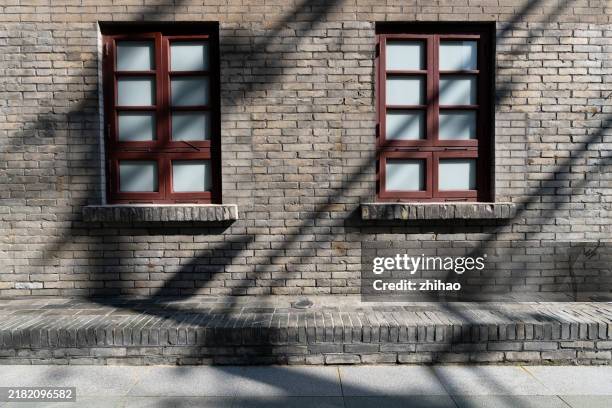 shadow on a brick wall with window frames - window sill stock pictures, royalty-free photos & images