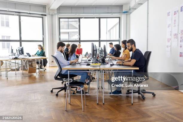 multiethnic business people working in an open plan office space. - western europe stock pictures, royalty-free photos & images
