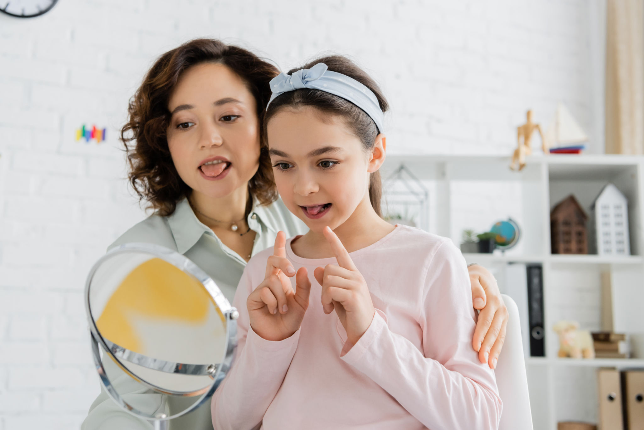 A speech therapist helps a child practice speaking in a bright consultation room A speech therapist helps a child practice speaking in a bright consultation room