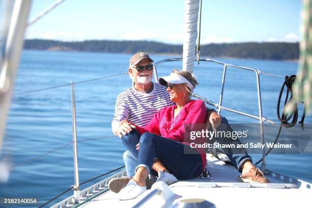 senior couple enjoying sailing together in the san juan islands - welvaart stockfoto's en -beelden