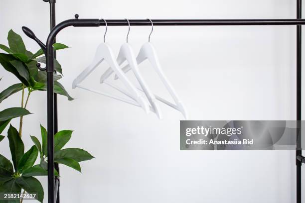 a group of clothes hangers on black railing. - kledingwinkel stockfoto's en -beelden