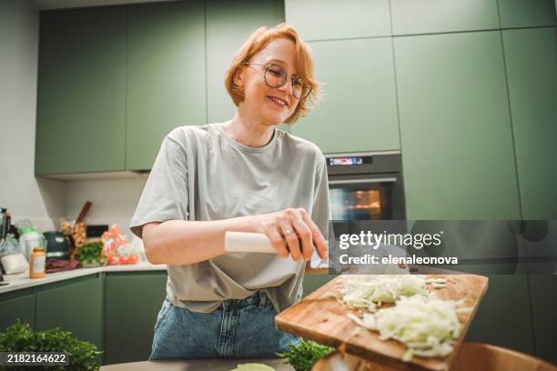 woman preparing salad in the kitchen - chopping food stock pictures, royalty-free photos & images