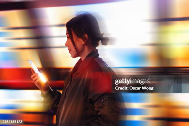 young asian woman using smartphone in a virtual reality (vr) environment - künstliche-intelligenz stock-fotos und bilder