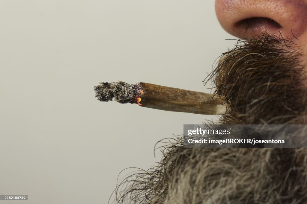 Close-up of a bearded man smoking a medical marijuana joint