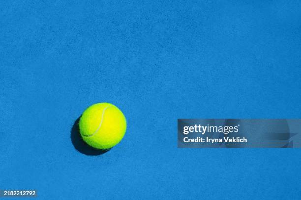 sport concept with tennis ball on blue hard tennis court background with shadow. - hardcourt stock pictures, royalty-free photos & images