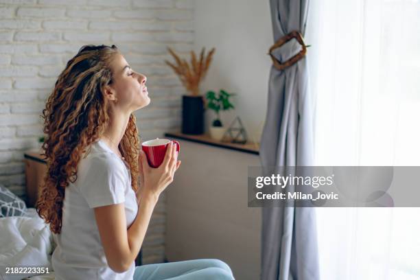 beautiful woman enjoying the morning while drinking coffee - cheerful stock pictures, royalty-free photos & images