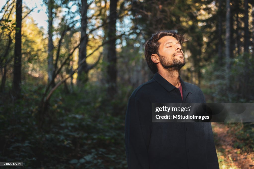 Portrait of man enjoying the sunny day in the forest